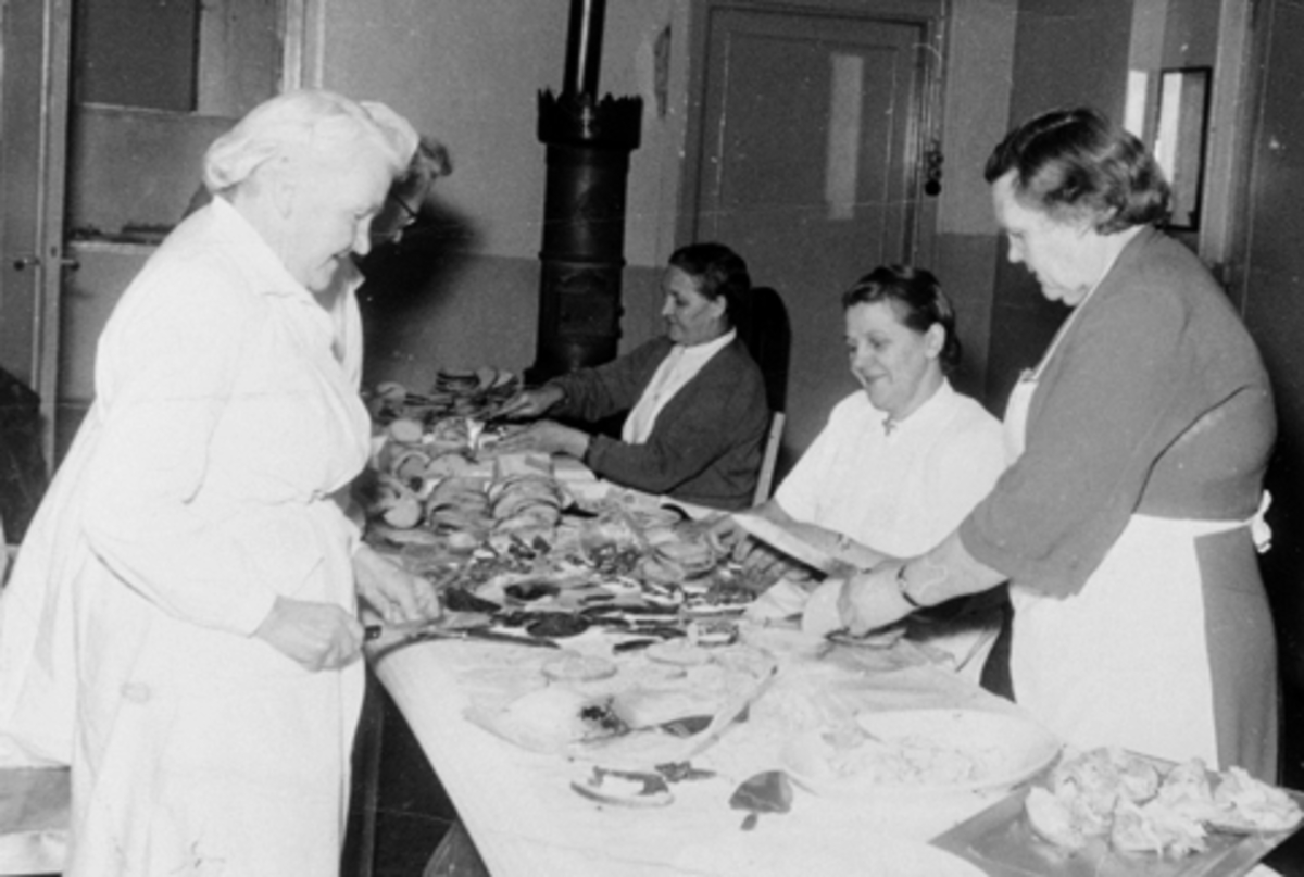 Bjørktun forsamlingslokale i 1940-årene. Dugnadsarbeid med smørbrødskjæring, kvinnen i mørk jakke er Agnes Bakken resten ukjent.