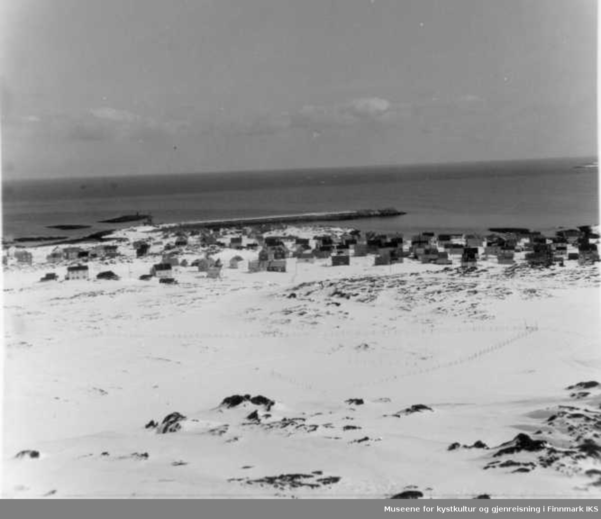 Bebyggelse fra "Lund-Fjæra" og vestover. Svartoksmoloen med tetrapoder ytterst på molohodet, ca 1963