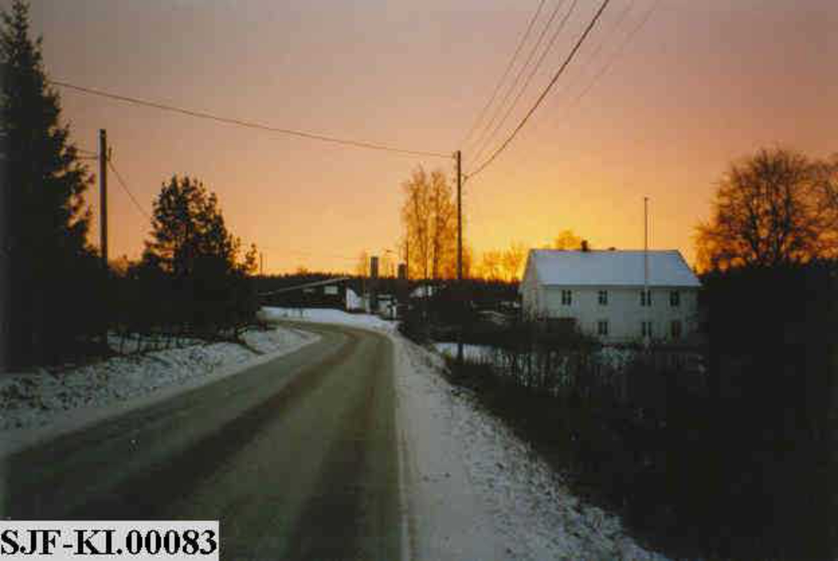 Soloppgang over industristedet Klevfos på Ådalsbruk i Løten i Hedmark.  Bildet er tatt fra riksveg 161 (her kalt «Klevbakken»), fra en posisjon nordvest for Klevfos-anlegget. Til høyre i bildet ser vi våningshuset på «Hasselbakken», som lenge var bolig for bestyrerne ved Klevfos Cellulose- & Papirfabrik.  Fra 1960-åra ble huset kontorisert.  Sentralt i bildet, men noe mer i bakgrunnen, skimter vi gavlen på verkstedbygningen og de to fabrikkpipene.  Bedriften Klevfos Cellulose- & Papierfabrik ble avviklet i 1976.  På dette tidspunktet var Klevfos Norges minste papirfabrikk, og sannsynligvis også den som hadde den minst oppdaterte produksjonsteknologien.  Fabrikken hadde nemlig i liten grad vært gjenstand for fornyelser etter at den ble gjenoppbygd etter brann i perioden 1909-1911.  En del entusiaster ivret for at anlegget måtte ivaretas som teknisk-industrielt kulturminne.  Klevfos ble gjenåpnet som museum i 1986.  Museet bruker Hasselbakken som møte- og selskapslokale.