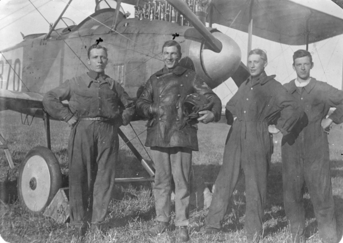Porträtt av fyra män framför flygplan Thulin FA nr 870.