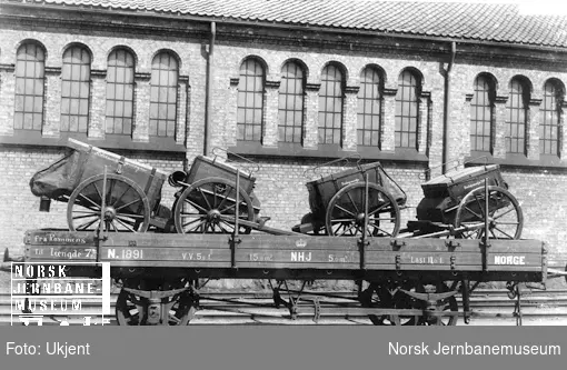 Hovedbanens vogn litra N nr. 1891 lastet med artillerimateriell; bøssemakervogn og beslagsmakervogn