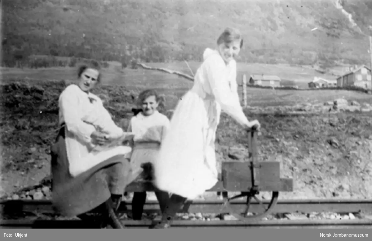 Tre damer poserer på en sparkedresin