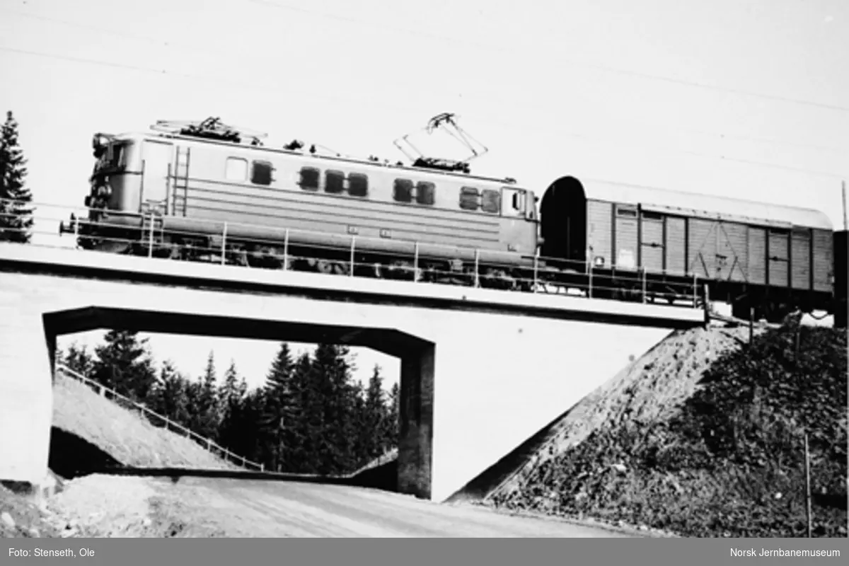 Elektrisk lokomotiv type El 13 med godstog passerer en nyanlagt vegundergang