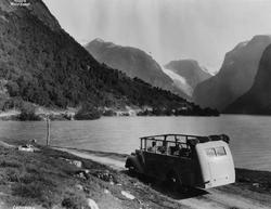Åpen minibuss på veien ved Lovatnet i Stryn. Fjord og fjell