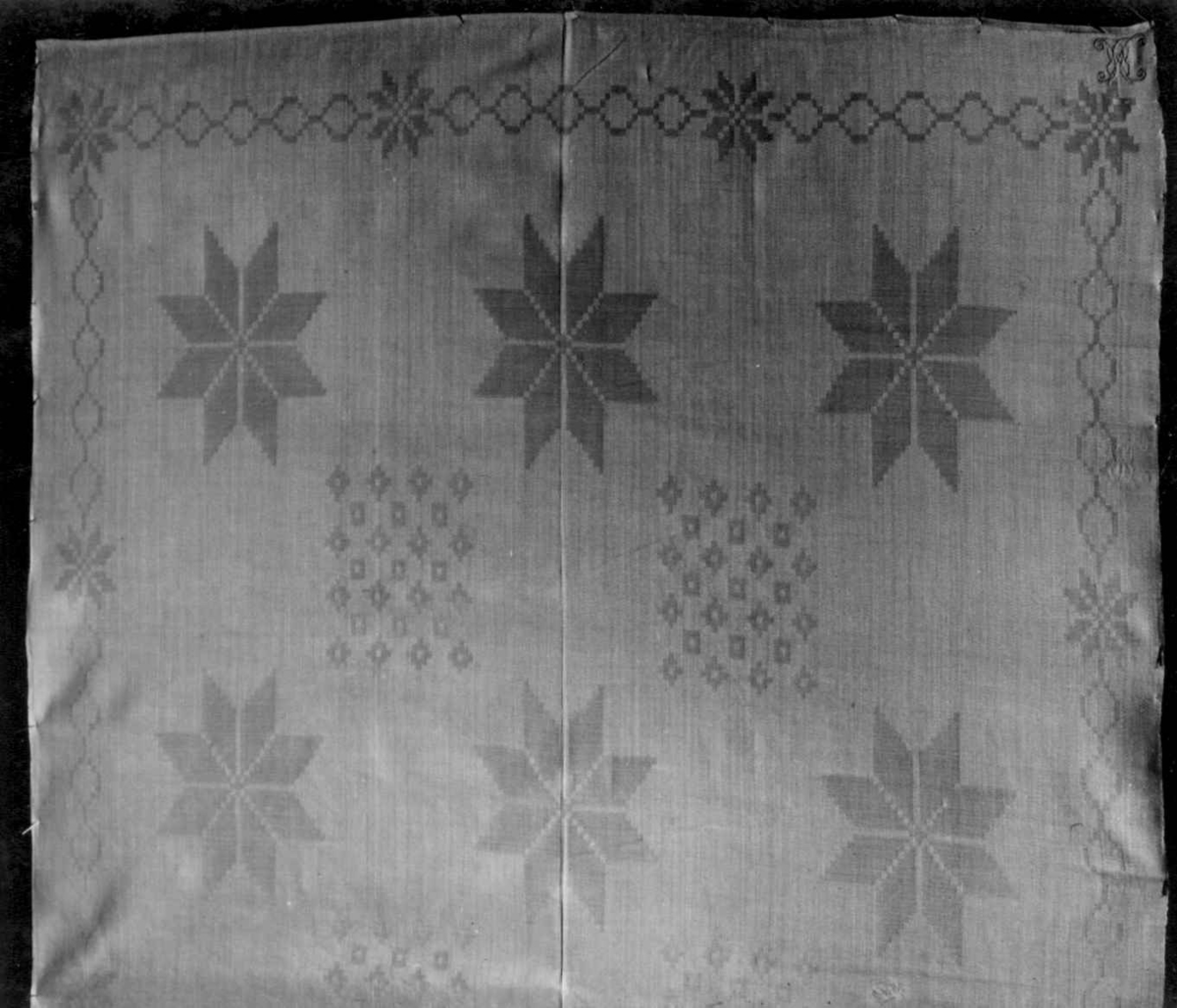 Hvit serviett i dreiel med stjernemønster. Fra 1750-60.