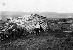 Gutt med vidbremmet hatt og hvit skjorte foran sammenfalt ut