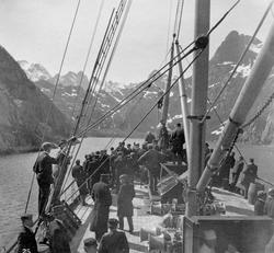 I Trollfjorden. Mennesker på dekket av en båt. Fjord og fjel