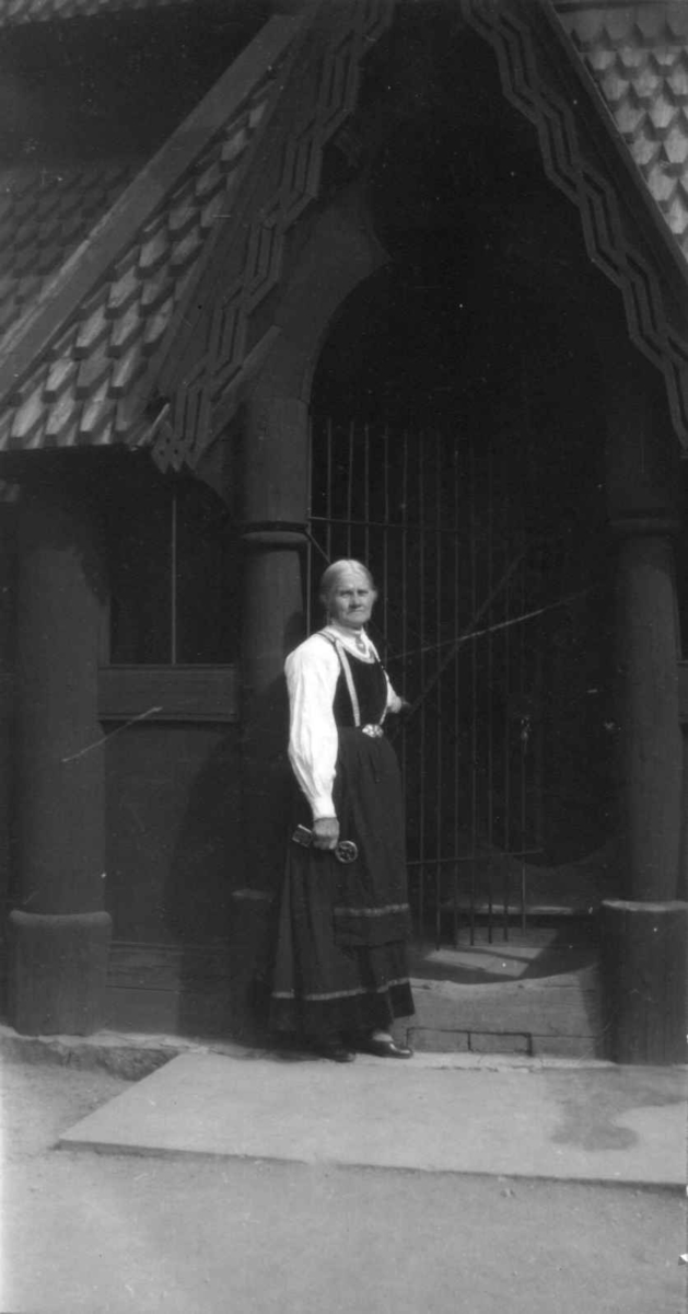 Ansatte, forøvrig museets eldste person i 1929, Asgjerd Haugen utenfor Stavkirken, bygning nr.181 på Norsk Folkemuseum.