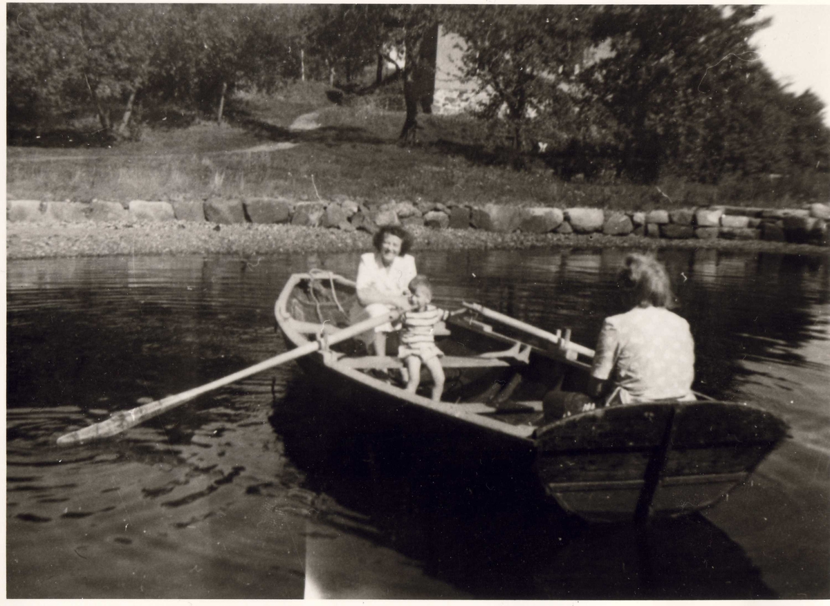 To kvinner og et barn i robåt. Ferieliv på Oslo Godtemplarungdomslags feriehjem Kirkevik, Nesodden, ca 1955