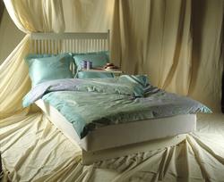 Hvit dobbeltseng med blått sengetøy. Illustrasjonsbilde fra 