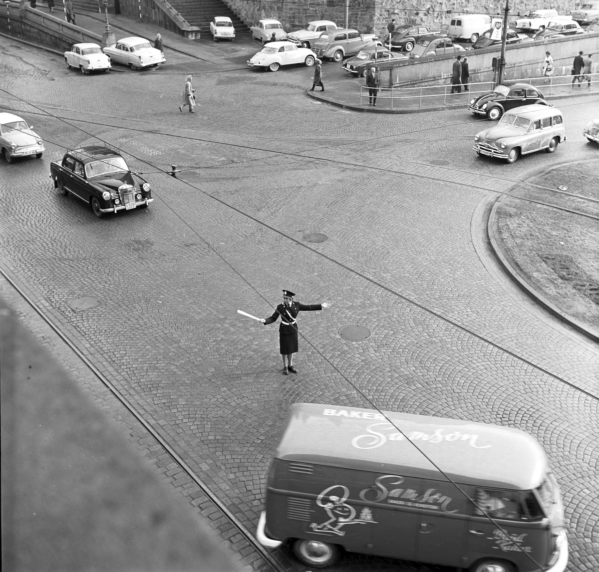 Serie. Kvinnelig trafikkpoliti. Én av dem dirigerer trafikken i krysset  Akersgata/Teatergata. Fotografert april 1962.

