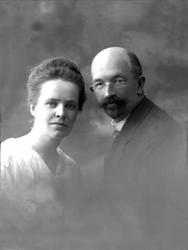 Gruppeportrett, ektepar, lys drakt og dress. Briller og skje