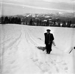 Vang, Oppland, 16.01.1954. Mann trekker kjelke.