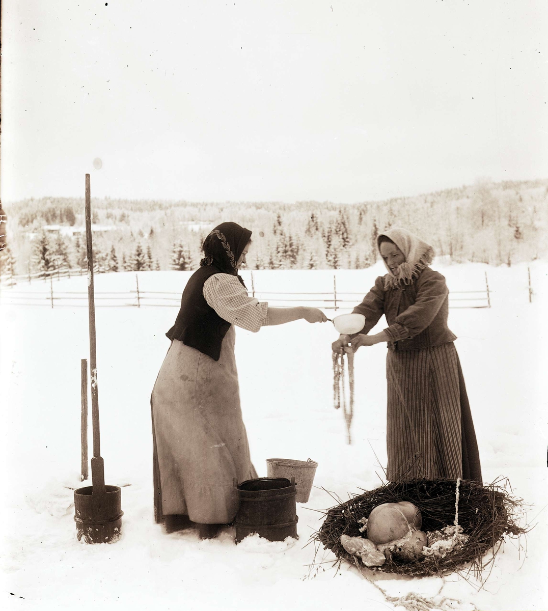 Slakt. Två kvinnor sköljer fårtarmar på vintern utomhus. "Tarmvänning"