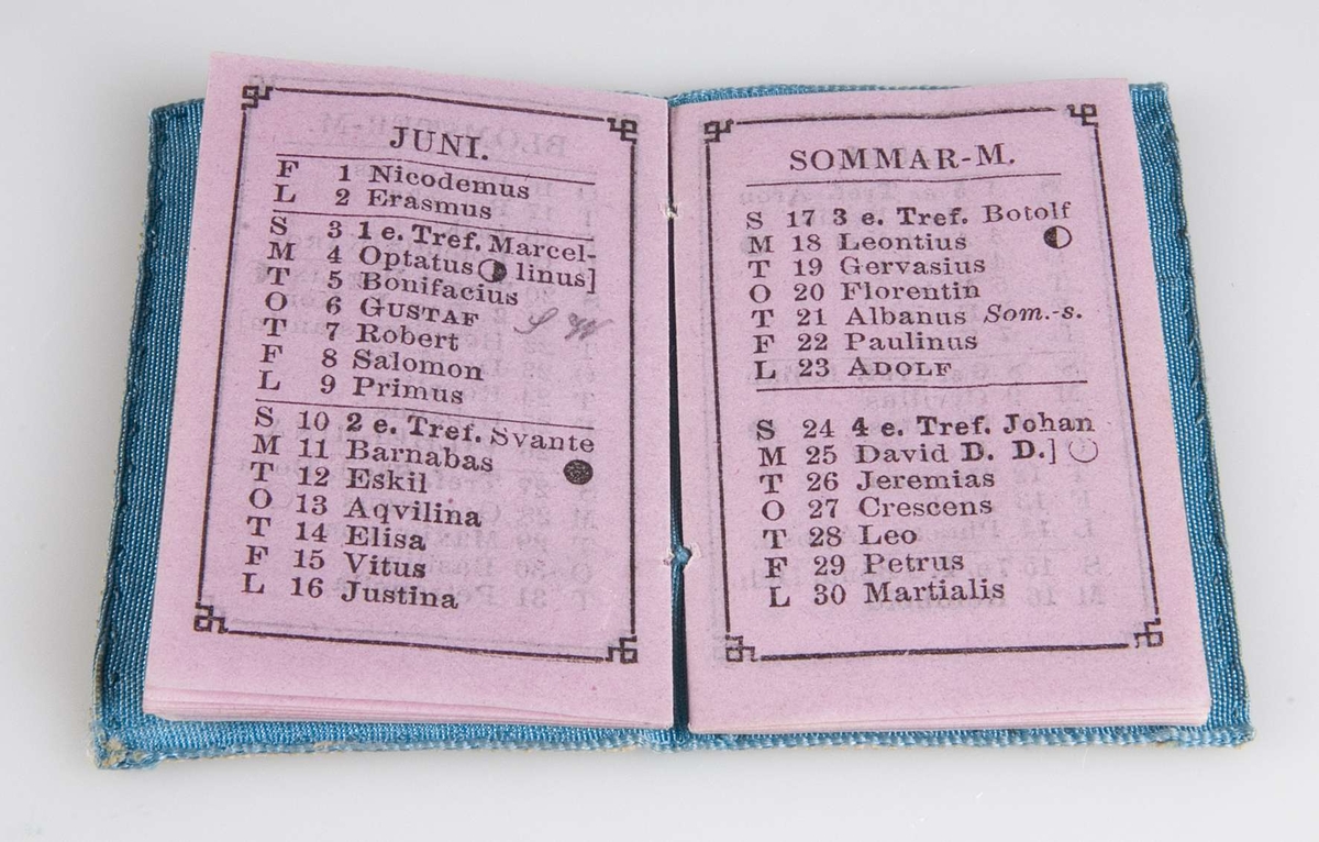 Rektangulärt liten almanacka (Fick-kalender för året 1877) med pärm i blått tyg. Mönster i vitt, genombrutet papper. På framsidan står initialerna HB (Helena Bosaeus). Själva kalendern är tryckt på rosa papper. Almanackan innehåller uppgifter om kungahuset, namnsdagar samt årets predikotexter.