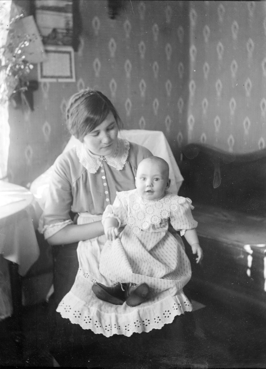 Kvinna och spädbarn i hemmiljö, Tierpstrakten, Uppland omkring 1915 - 1920
