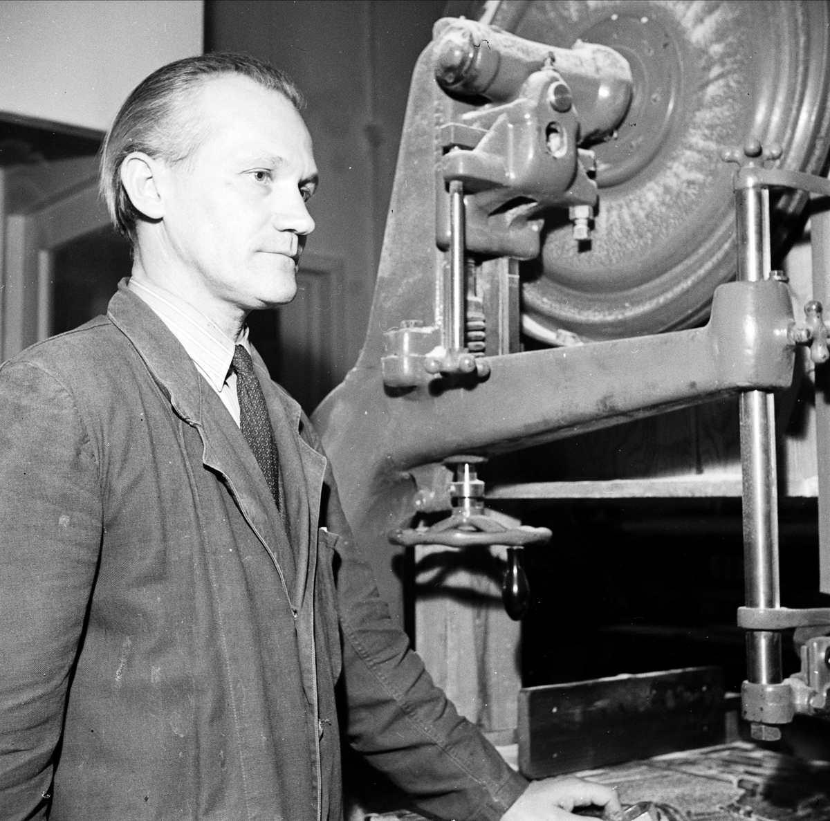 Man vid maskin på industri, sannolikt Uppsala, 1948