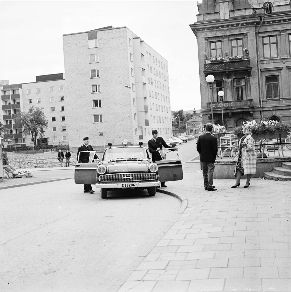 "Lugn' sommarkväll jobbig för radiopolisen" - poliserna Inge Ivarsson och Ove Brunn har stannat vid Uppsala busstation på Kungsgatan för en rutinkontroll, 1964