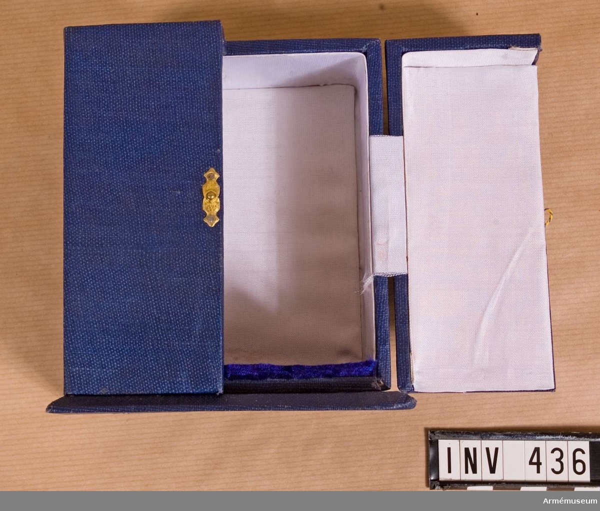 Samhörande nr är 294-299, 321-350, 400-448 (435-436).
Fodral t minnestecken.
Från ingenjörtruppskolan i Poona (Pune), Indien. Överlämnat 1975-01-25 under CA besök vid indiska arméni Poona ( jan 1975. "From Maj.Gen. K C Soni, AVSM, Commandant, Commandant, College of Military Engineering, Pune." Asken i blå klot är utformad som ett litet skåp med två dörrar, som låses på mitten med ett litet spänne. Invändigt klätt med vitt konstsiden och botten med blått sammet. Mått, botten: 115x85 mm, asken: 120x70 mm.