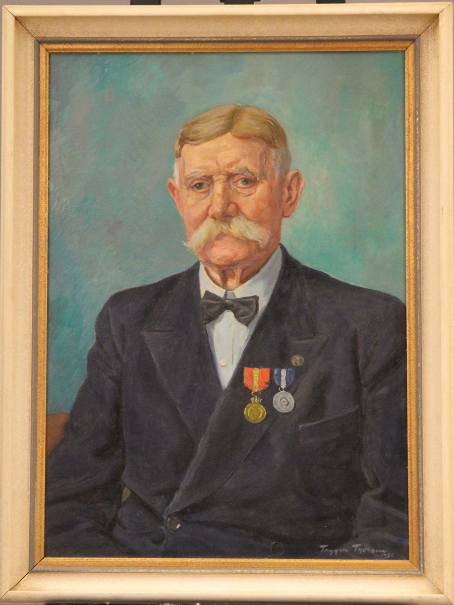 Portrett av æresmedlem, distriktsformand og dampskipsekspeditør H. Martinussen, Svolvær, med tvertoversløyfe og 2 medaljer.