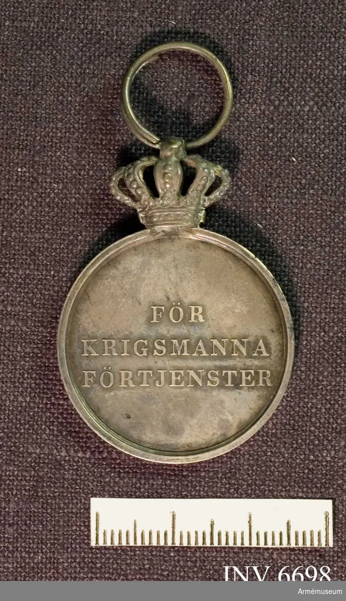 På åtsidan ses på en glob Sveriges tre kronor med ett  upprättstående svärd och omskriften "Konung och fädernesland",  på frånsidan inskriften "För krigsmannaförtjänster". Medaljen är av silver och bäres i gult band med blå kanter.