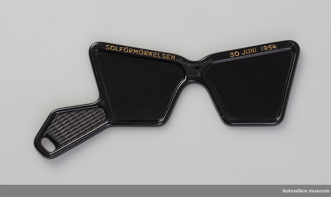 Skyddsglasögon tillverkade vid Husqvarna Borstfabrik inför solförmörkelsen den 30 juni 1954. Nästan helt ogenomskinlig svart plast har använts i produkten.
Föremålen märkta UM19507:1, UM19507:2 och UM19507:3