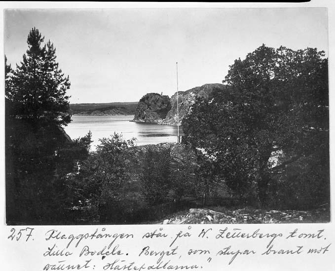 Text på kortet: "257. Flaggstången står på W. Zetterbergs tomt. Lilla Bodele. Berget som stupar brant mot vattnet: "Hästepallarna".