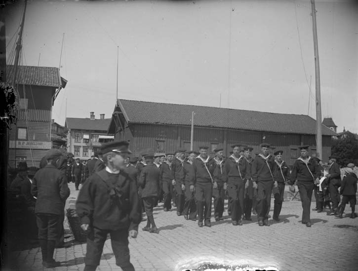 "Lysekil. Skeppsgossar tillhörande Najaden, Gladan, Falken på ångbåtsbryggan den 25 juni 1899"