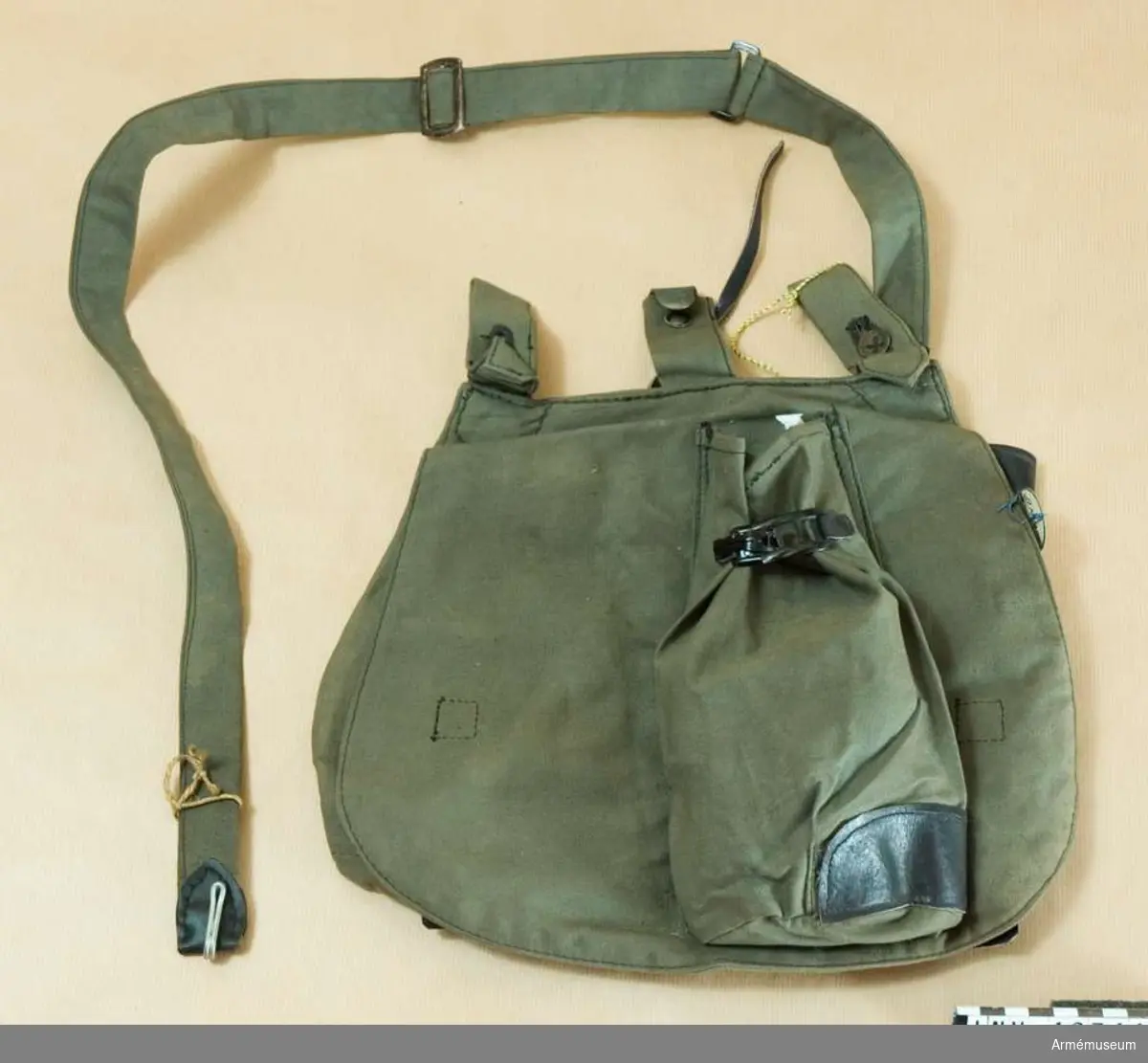 Grupp C II
Brödväska för menig, Holland. 1917. (Brotbeutel) av mörkgrått,tjockt tyg med två hylsor som stänges med knappar och krok för att hänga väskan på bältet. På framsidan finns en ficka som stängs med sölja. På väskans inre sida finns en ficka av svart läder med lock som stängs med knapp och en stämpel "G.M. 1917". För att stänga väskan finns inuti två svarta läderremmar och  två knappar. Väskan har axelgehäng av samma tyg med ring och spänne.
