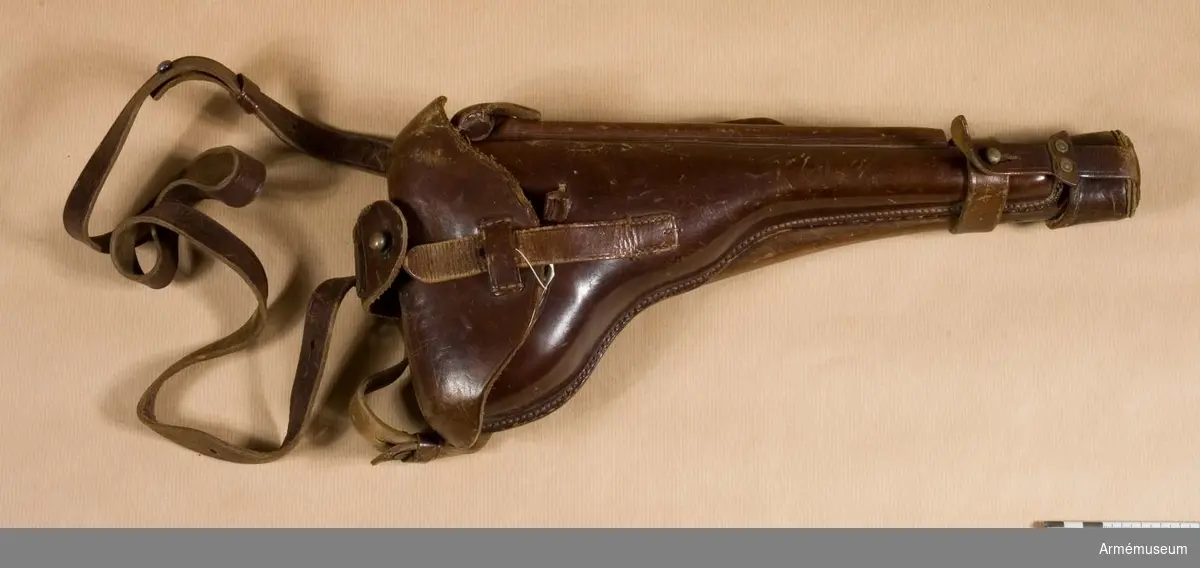 Grupp E III.
Hölstret är tillverkat av läder och är fastspänt på en tunn löskolv av valnöt. Pistolen går både under benämningen m/1914 och m/1917.
