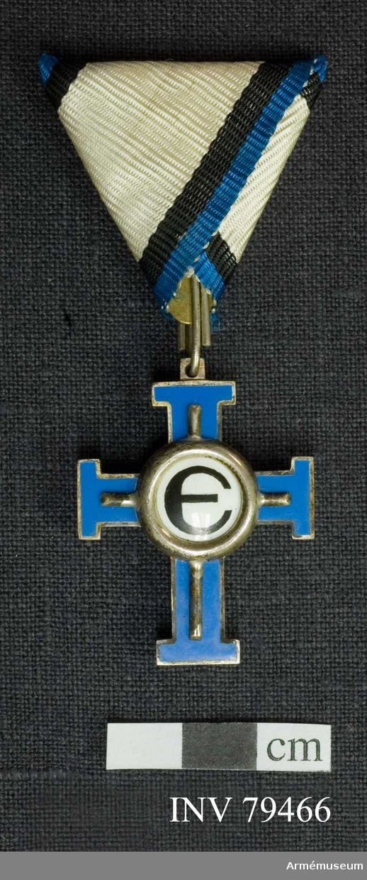 Grupp: M. 
Dekorationen är till form och storlek lika med AM.016330, men färgen på korsets emalj är ljusblå. 
Åtsidan: är lika med AM.016332 utom att det i upphöjningen befintliga E saknar silverkanter. 
Bandets mittrand är vit, sidoränderna svarta (innerst) och blå. 
Estländska frihetskorset 3:e graden 3:e klassen chevalier för civila förtjänster.
