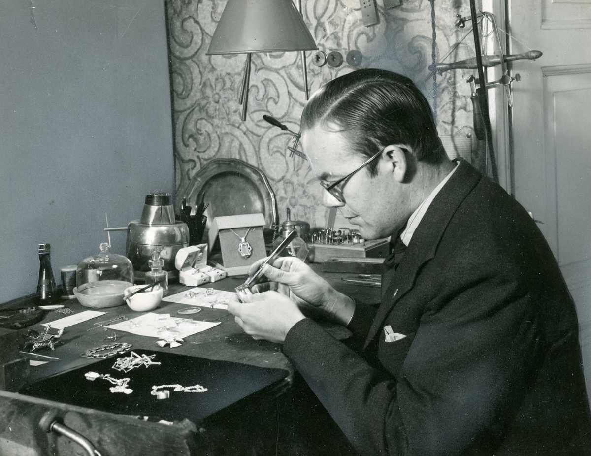 Emilsons verkstad. Interiör från Emilsons verkstad. Guldsmeden i färd med att inpassa bergkristallen till Emilson-smycket. Foto C E Sandblad, Laholm, 1941.