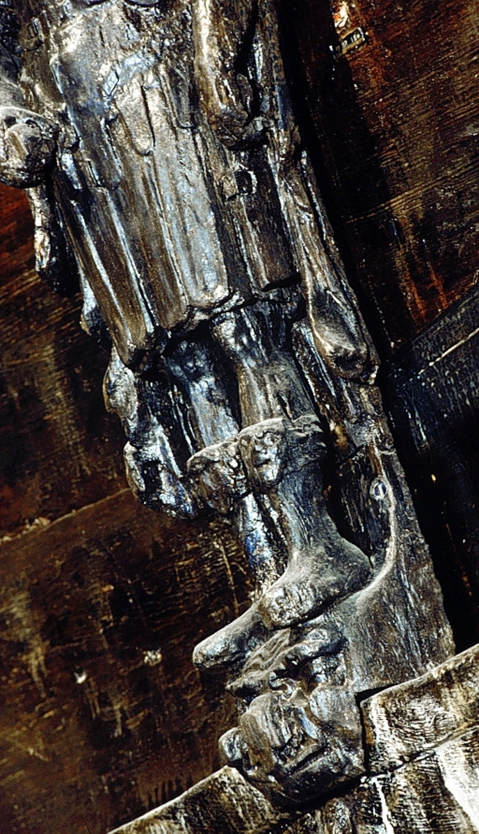 Skulptur föreställande en mansfigur med lagerkrönt huvud och en thoraxrustning med axelprydnader i form av lejonhuvuden. En lång, utefter ryggen nedhängande mantel, är draperad runt halsen och hopfäst på höger axel. Ansiktet har en bred näsa samt ett kort och krusigt skägg. Pannan är rynkad.
Figurens huvud är frontalställt medan bålen är vriden något mot vänster. Höger arm hålls något böjd snett framför magen med handen fattande om ett svärdsfäste. Den vänstra armen, också den böjd, är placerad utefter sidan. Handen fattar om en kula eller ett klot. Kroppstyngden förefaller vara fördelad på bägge benen.
Figuren står på en sockel, vilken pryds av en grotesk maskaron med rynkad panna och bred nos. Under maskaronen syns en banderoll, med inskriptionen TUS.



Upptill är bakstycket framdraget i en "huvudplatta", med en kvartscirkelformad profil. Huvudplattan är formad till en kraftig och svagt ornerad vulst, med upprullade ändpartier.



Skulpturens baksida uppvisar två snedställda, olika djupt liggande fält. De två fälten, som utgör anliggningsytor, ger skulpturen en trappstegsformad profil.

Svärdsklingan saknas. I övrigt är skulpturen mycket välbevarad.



Text in English: A sculpture representing a male figure with a laurel-wreath. The face has a wrinkled forehead, a broad nose and a short beard. The figure is wearing thorax armour with a shoulder decoration in the form of a lion''s head. The mantle hangs down from the back and is draped round the neck and secured on the right shoulder.



The figure''s head faces foward while the body is turned a little to the left. The right arm is held slightly bent in front of the stomach and the hand grips the hilt of a sword. The left arm, also slightly bent, is at the side with the hand holding a ball or spere. The weight of the body is carried equally on both legs.



The figure stands on a plinth, decorated with a grotesque mask with a wrinkled forehead and broad nose. Below the mask there is a label with the name TUS.



The upper part of the back extends obliquely upwards in a "head board". The head board is shaped like a powerful bulge, slightly ornate, with rolled up ends.



The back of the sculpture has two obliquely placed flat surfaces of different depths that are areas of attachment. The flat surfaces make the sculpture look like a step-ladder in profile.

The blade of the sword is missing, otherwise the sculpture is very well preserved.