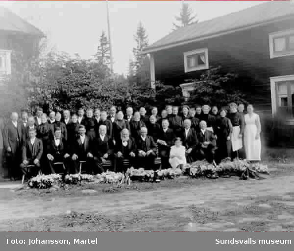 Gruppbild i samband med begravningen av Per Jansson från Sunne i Värmland, farfar åt fotografen Martel Johansson och hans syskon. Fotot taget i trädgården på gården Brännsvedjan i Sörfors.
