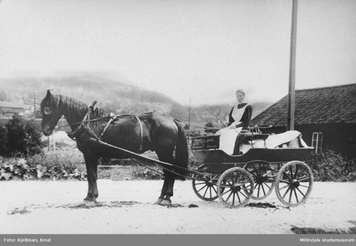 "Mjölksurra" vid Göteborgsvägen omkring år 1900. Pigan var då anställd hos lantbrukaren Karl Lindström, Kärrabro. Bortom: Omnibusstallarna.