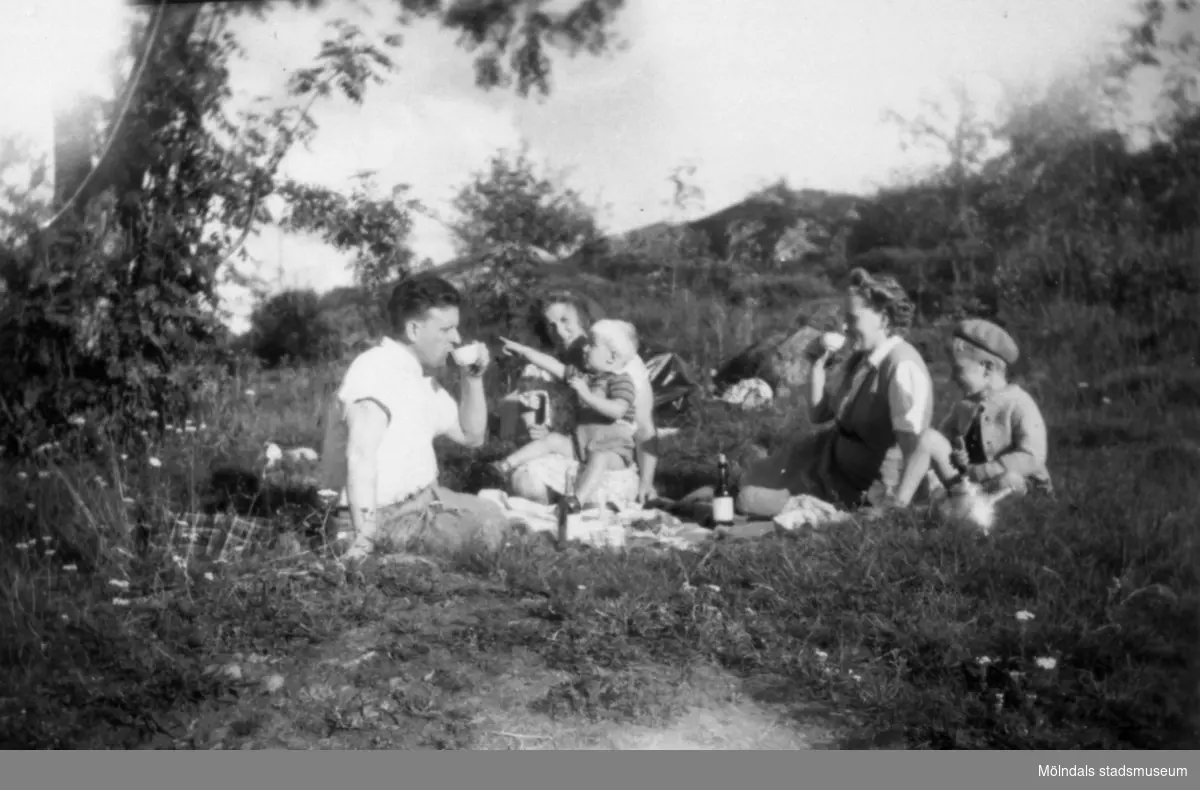Familjerna Garthman och Eriksson sitter i det gröna och fikar i Mölndal. Från vänster: Helmer Garthman, Doris Eriksson med Bert Eriksson i knät, Astrid och Alf Garthman. 1950-tal.