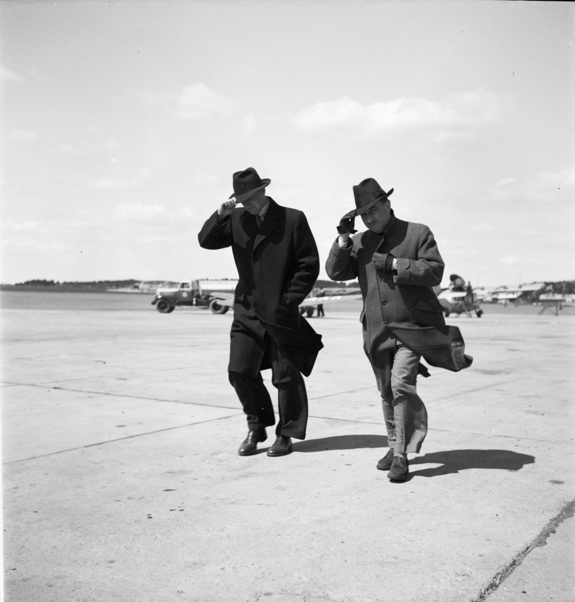 Herrkläder
Två män i hatt i motvind på en flygplats