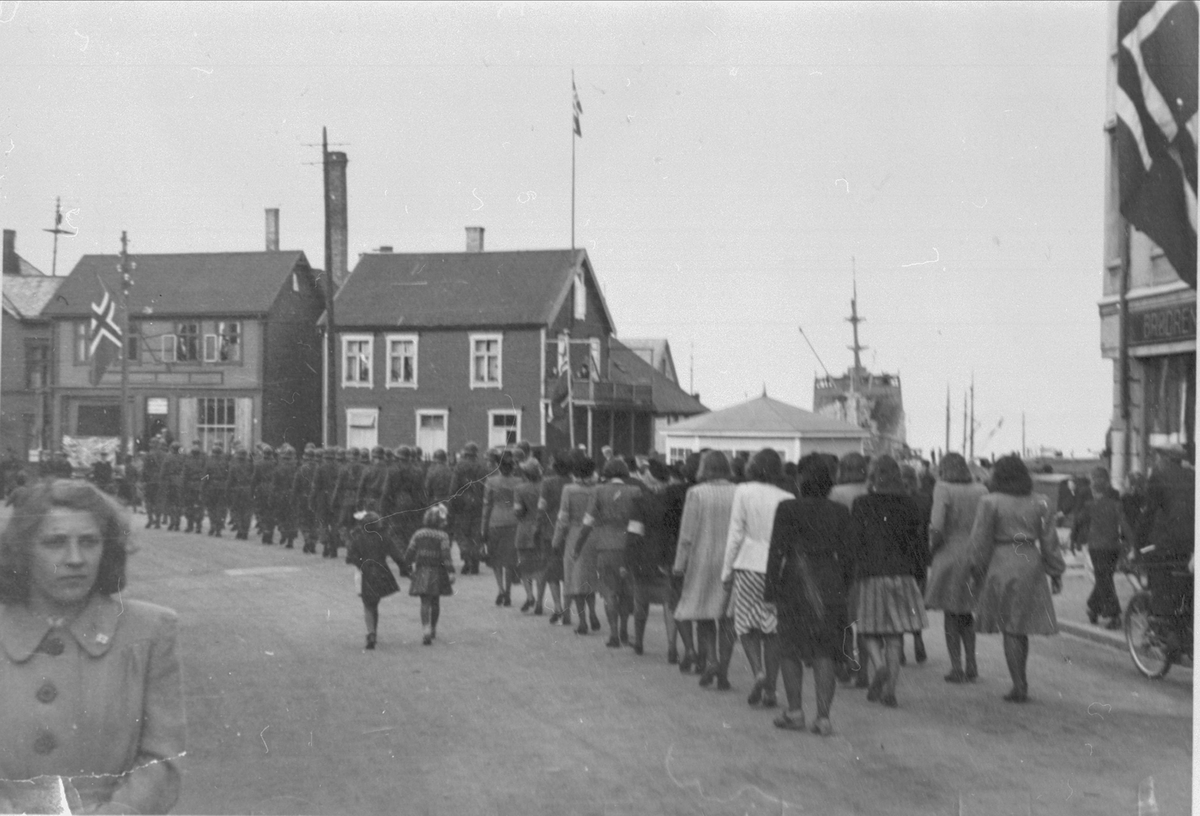 Soldater og kvinner med armbind marsjerer i sentrum, 1945.
