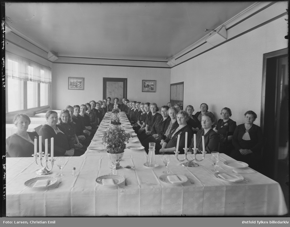 Kooperativt kurs for kvinner, 1946. Antakelig i Sarpsborg -distriktet. Ukjente kvinner og mann rundt pyntet langbord.