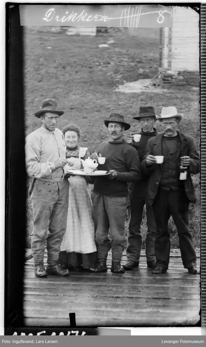 Gruppebilde av fire menn og en kvinne som har kaffepause.