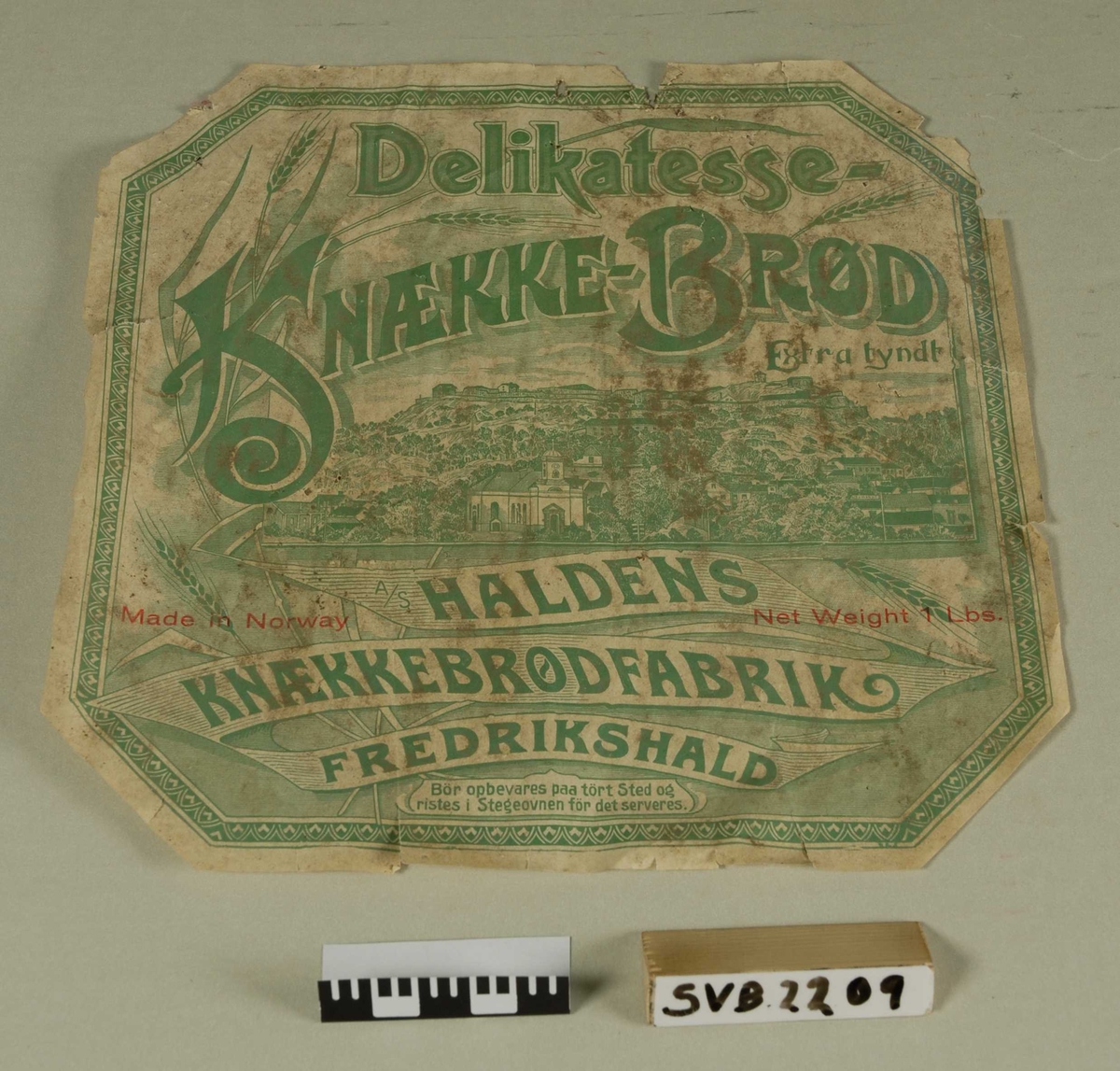 Etikett for knekkebrød-boks. Hvit med grønt trykk og noe rød skrift