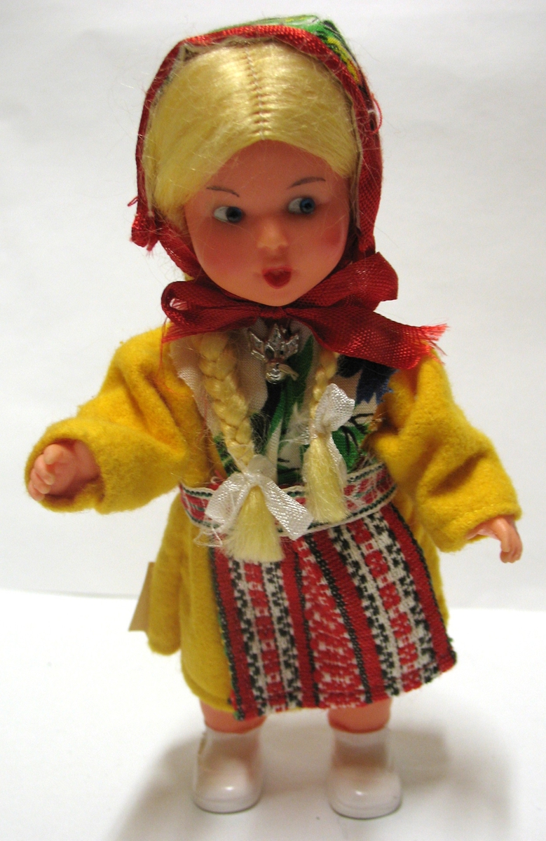 Tillhör Vera Hanssons docksamling.

Marit, i barndräkt från Leksand. Dalarna.
Köpt 1969.
Gul klänning, rödrandigt förkläde, blommig hätta och schal.