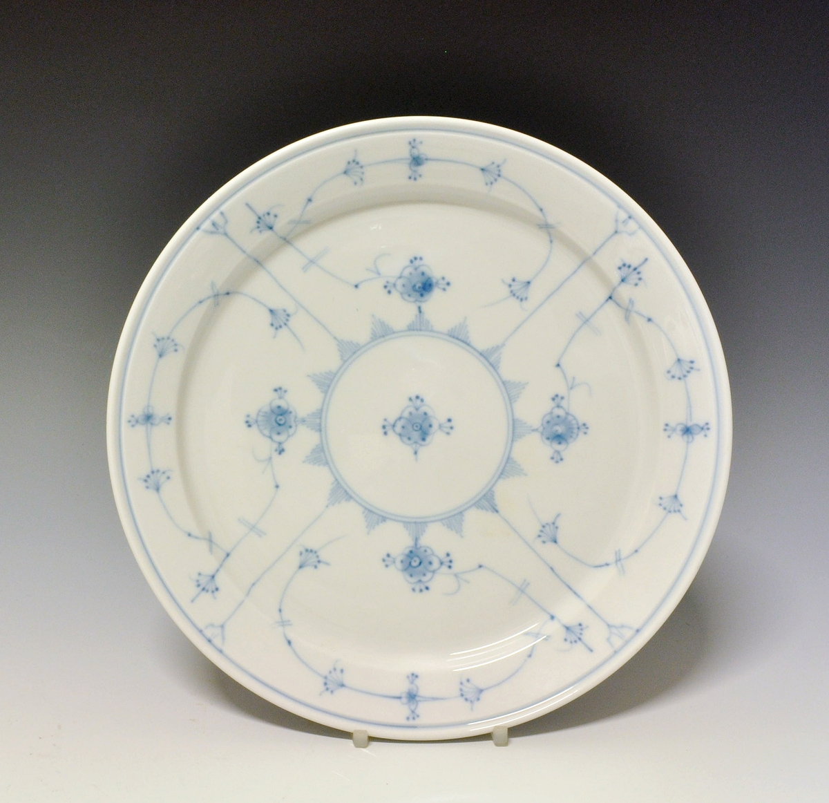 Flat tallerken i porselen, med glatt kant.
Dekor: Stråmønster i blått
Modell: 2440, Eystein Sandnes