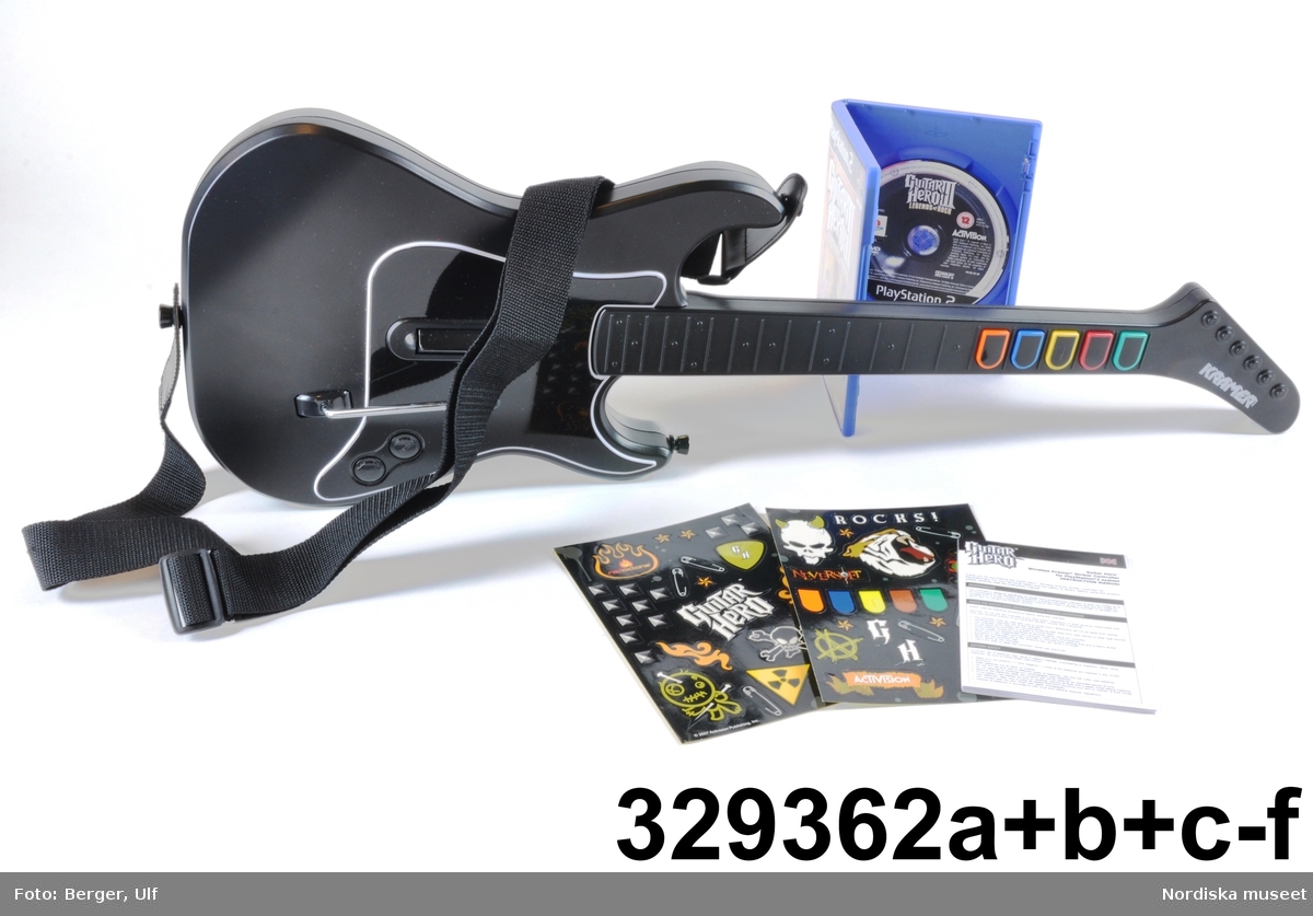 TV-spelet "Guitar Hero III Legends of Rock" med förpackning. 
a+) Elgitarr med avtagbar hals, av svart plast, svart axelrem av syntettextil med konstläder (plast) och plastöglor.
b+) 2 ark med klisterbilder att fästa på gitarren
c) Broschyr med instruktioner om funktion och säkerhet på flera olika språk.
d) Fodral av blå plast med inplastat omslag av papper med text. På framsidan "Playstation 2 / Guitarr Hero III LEGENDS of ROCK" och bild på hårdrockare. Baksidan bl.a. "SLÄPP LOSS DIN INRE ROCKLEGEND / Över 70 rockiga låtar.".
e) CD-skiva med programvara (förvarad i fodral d).
f) Instruktionsbok på de nordiska spårken (förvarad i fodral d) 
g+) Förpackning av papp. Ytterfodral med text och bilder. Inre lådan med inredning för de olika delarna.
 
Tv-spelet är avsett för spelplattformen Playstation 2, vilket är en vanlig spelplattform. Spelet går ut på att det spelas upp en låt (man väljer själv låt och nivå) och ska sedan försöka spela på gitarren genom att trycka på knapparna och på så vis lyckas spela samma ton som musiken spelar samtidigt.

Vid förvärvet avlägsnades plastpåsar som del av a och b låg i, samt två 1.5volts-batterier av märket Duracell som låg i gitarren, då de ej bedömdes möjliga att spara. Även fyra papperspåsar med Silicagel (för att hindra att fukt skadar elektronik mm) togs bort.

Nyinköp den 2008-02-20 för att rekonstruera julkklappsönskemål julen 2007 från Erik Thomelius född 1999, Vaxholm. Inköpt av Nordiska museet för 439 kr. Ingår i projektet "Barn tar plats". Se dokumentation i arkivet D455.
/Ulf Hamilton 2008-05-27     