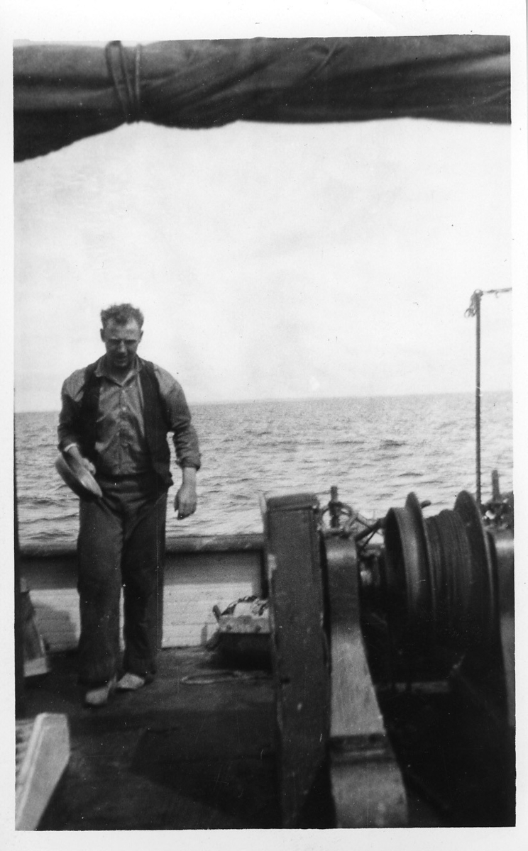 'Kattegattexpeditionen 1933: ::  :: 1 st man med stekpanna i ena handen gående på båtdäck. Enligt anteckning på baksidan av fotografiet: ''kocken''. ::  :: Ingår i serie med fotonr. 2804-2826.'