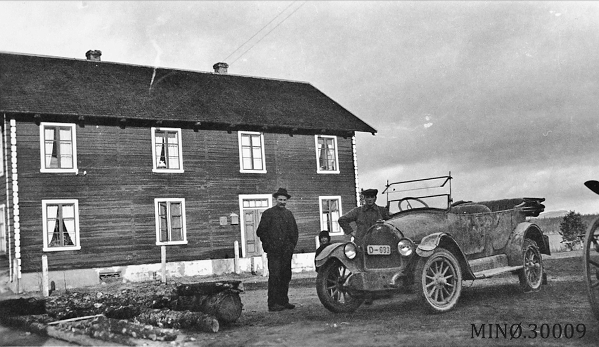 To menn med bil foran bolighus