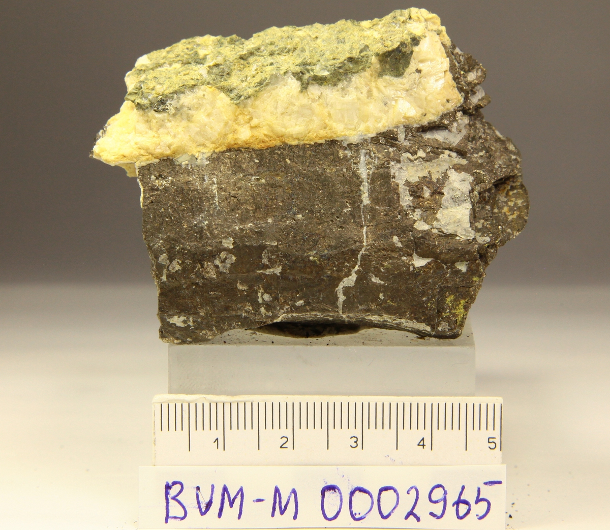 Grovkornet pyrrhotitt, mulig 2 krystallflater, med hvit karbonat.
Mannsfjellstunnelen, E39, Skaun.