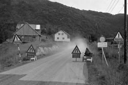 Veiarbeid i Grunnvassbotn. Skilt på veien i forgrunnen, gård