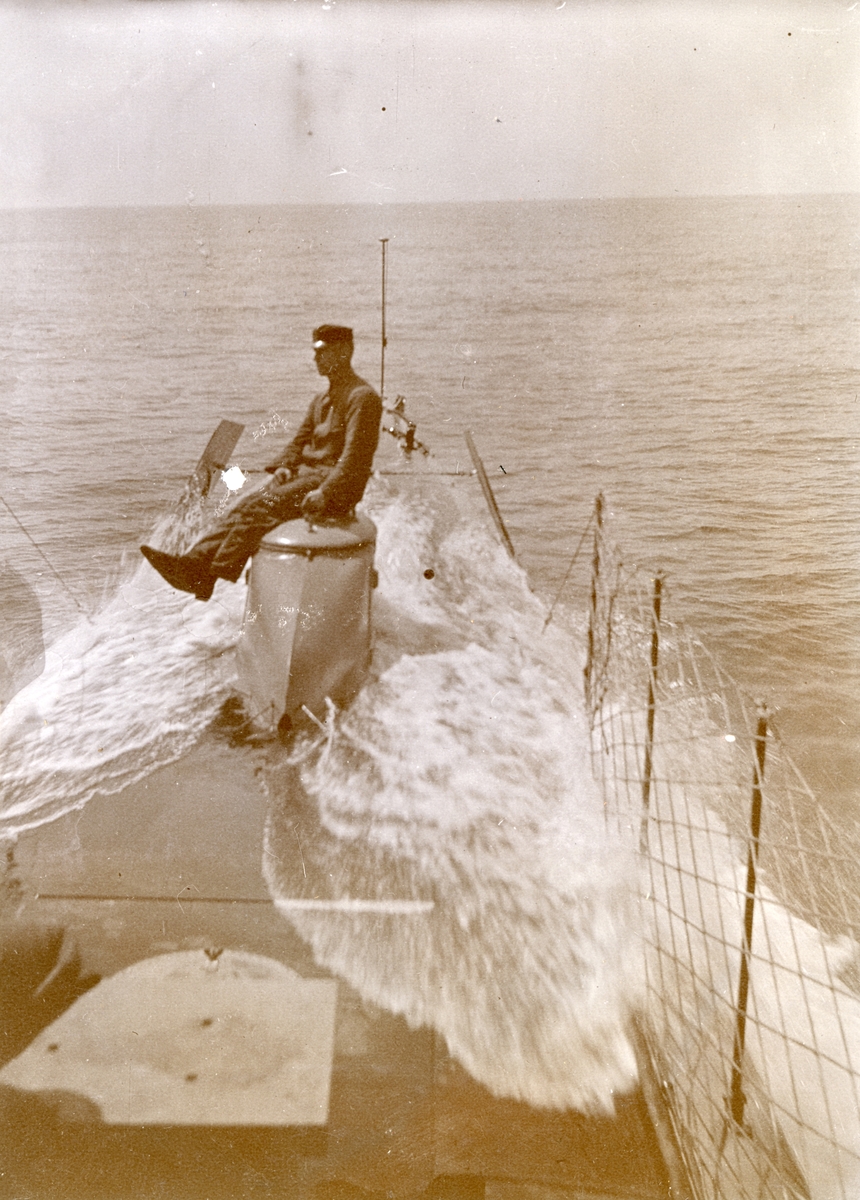 En besättningsman sitter på förliga manluckan vid överspolning till sjöss. Ubåten HVALEN.