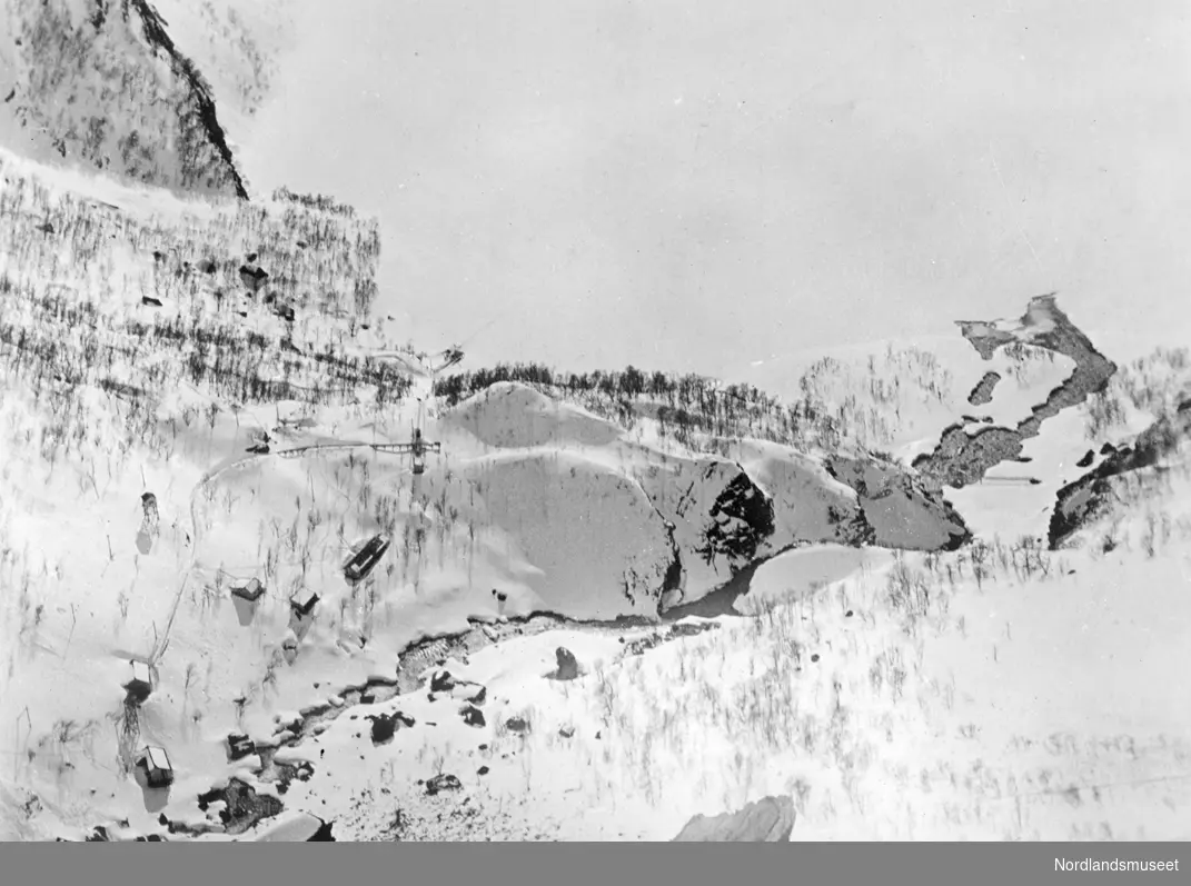 Fykandal og Fykanvann sett fra kjibba eller taubanen til Navervann. Bildet er tatt nedover bratt fjellside 20.mai 1917.Viser snødekt natur med noen hus/brakker langt nede 